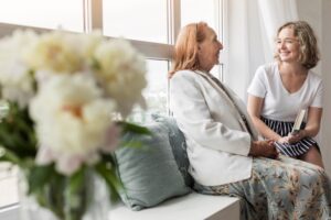 Une femme âgée souriante reçoit de la visite.